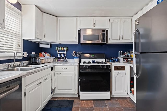 2508 Vernon Ave, Kansas City, KS 66104 - kitchen with appliances with stainless steel finishes, white cabinetry, light countertops, and stone finish flooring