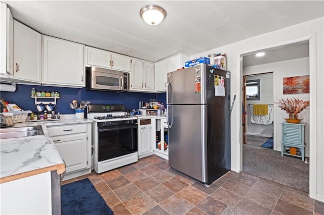 2508 Vernon Ave, Kansas City, KS 66104 - kitchen with stainless steel appliances, white cabinetry, and dark stone finish flooring