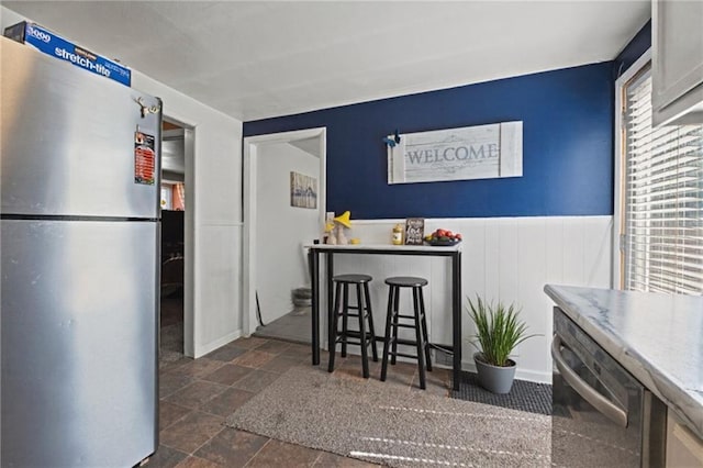 2508 Vernon Ave, Kansas City, KS 66104 - kitchen featuring appliances with stainless steel finishes, dark stone finish floors, and wainscoting