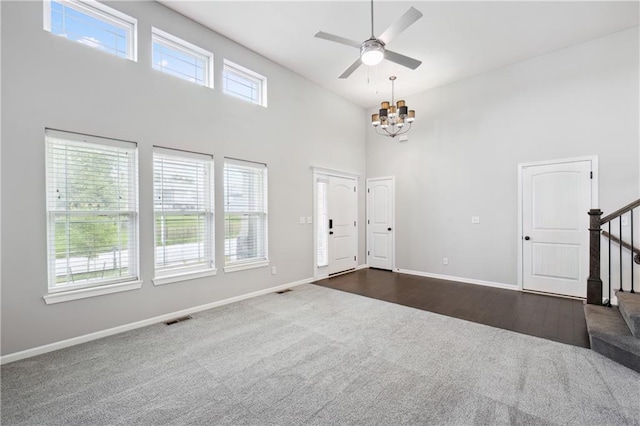 11704 N Laurel Ave, Kansas City, MO 64157 - entryway featuring dark carpet, a high ceiling, a chandelier, stairs, and ceiling fan