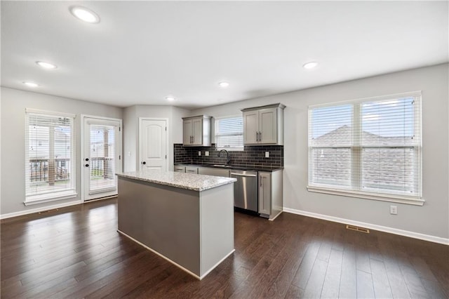 11704 N Laurel Ave, Kansas City, MO 64157 - kitchen with dishwasher, gray cabinetry, a kitchen island, backsplash, and dark wood-style flooring