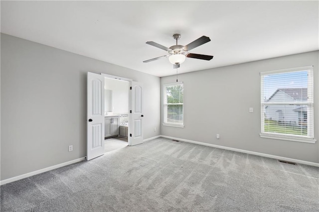 11704 N Laurel Ave, Kansas City, MO 64157 - unfurnished bedroom featuring light colored carpet, connected bathroom, and a ceiling fan