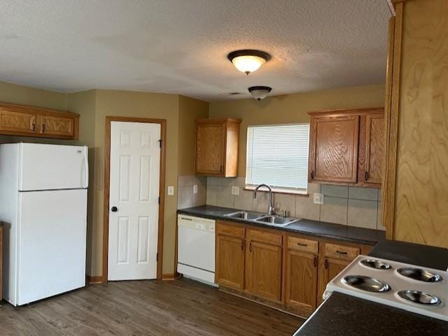 1002 NE Deer Creek Rd, Grain Valley, MO 64029 - kitchen with white appliances, dark wood finished floors, dark countertops, backsplash, and a textured ceiling