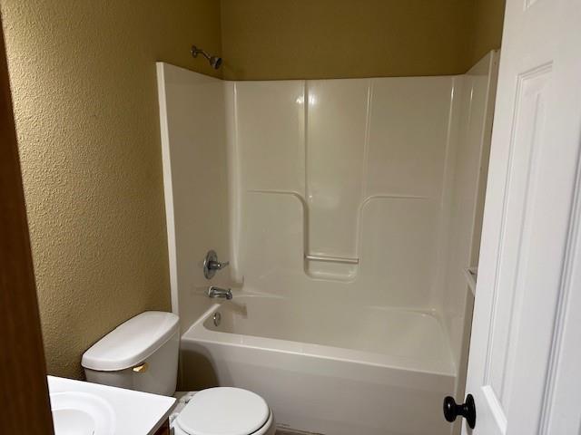 1002 NE Deer Creek Rd, Grain Valley, MO 64029 - full bathroom featuring a textured wall, vanity, and shower / tub combination