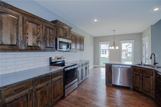 3718 NE 90th Ter, Kansas City, MO 64156 - kitchen featuring appliances with stainless steel finishes, dark brown cabinets, backsplash, dark wood-style floors, and recessed lighting