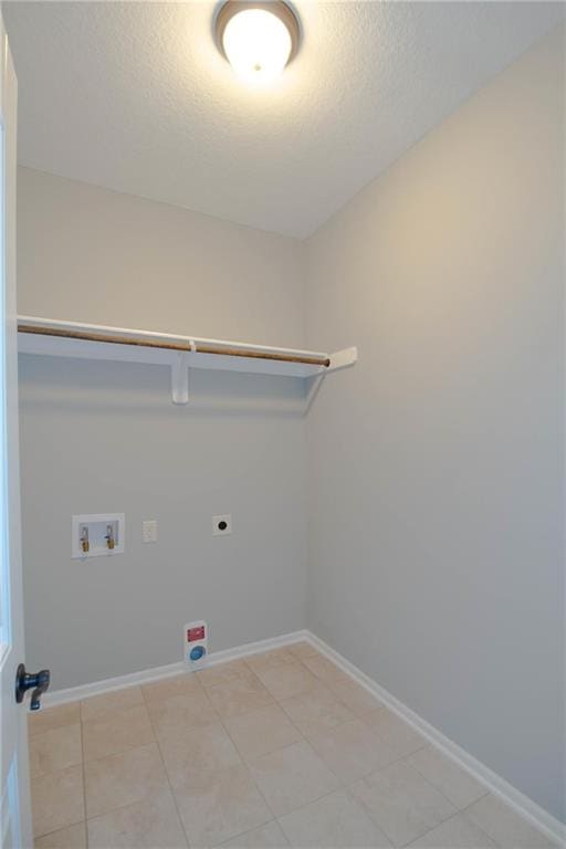 3718 NE 90th Ter, Kansas City, MO 64156 - laundry area with hookup for an electric dryer, washer hookup, a textured ceiling, and light tile patterned flooring