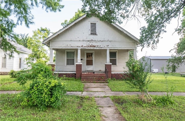 1015 Lincoln St, Neodesha, KS 66757 - bungalow featuring covered porch and a front lawn