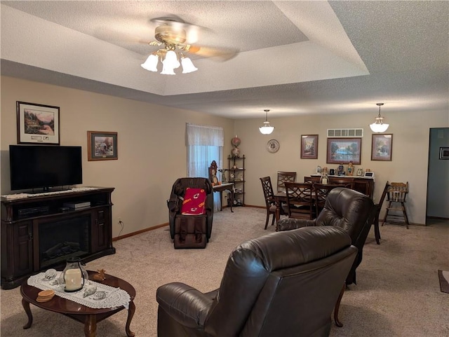413 Quail Trl, Warrensburg, MO 64093 - living room featuring light colored carpet, ceiling fan, a tray ceiling, and a textured ceiling