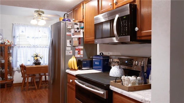 413 Quail Trl, Warrensburg, MO 64093 - kitchen featuring stainless steel appliances, brown cabinets, a ceiling fan, and wood finished floors