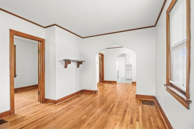 414 Dickinson Rd, Independence, MO 64050 - empty room with arched walkways, crown molding, light wood-type flooring, and healthy amount of natural light