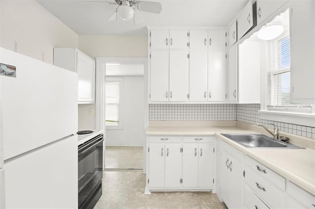 414 Dickinson Rd, Independence, MO 64050 - kitchen with freestanding refrigerator, range, ceiling fan, and white cabinets