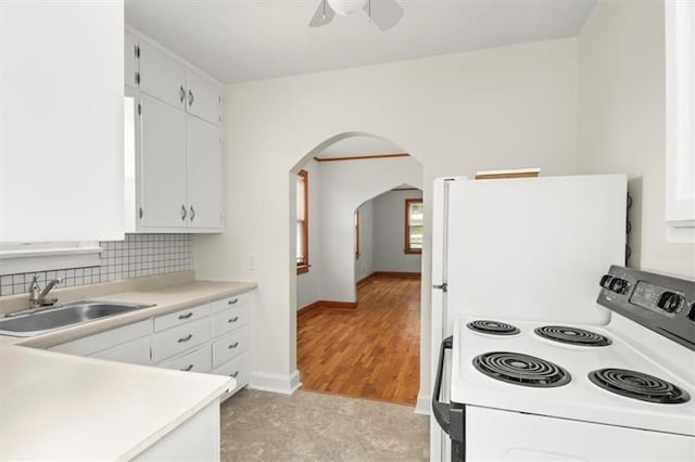 414 Dickinson Rd, Independence, MO 64050 - kitchen with white appliances, arched walkways, white cabinets, ceiling fan, and light countertops