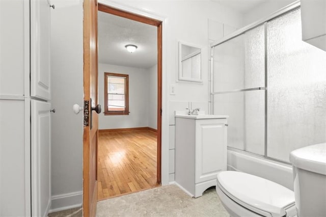 414 Dickinson Rd, Independence, MO 64050 - bathroom with vanity, shower / bath combination with glass door, and wood finished floors
