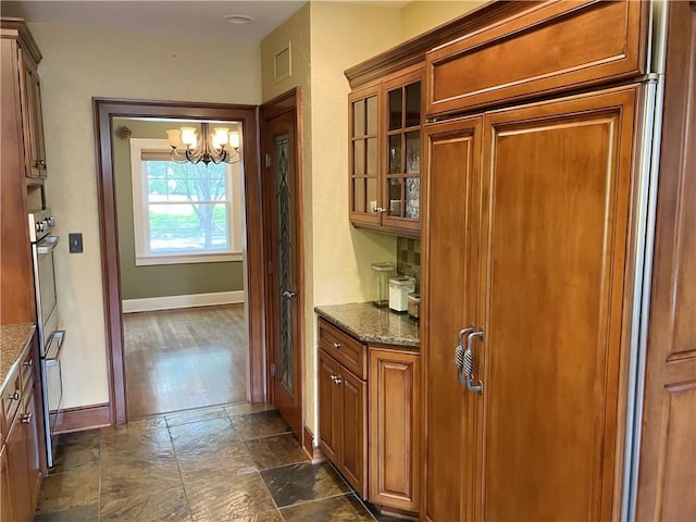 207 W 66th St, Kansas City, MO 64113 - bar with a chandelier and dark stone finish floors