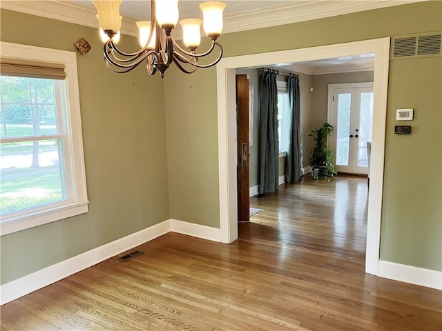 207 W 66th St, Kansas City, MO 64113 - unfurnished dining area with ornamental molding, plenty of natural light, a chandelier, and wood finished floors