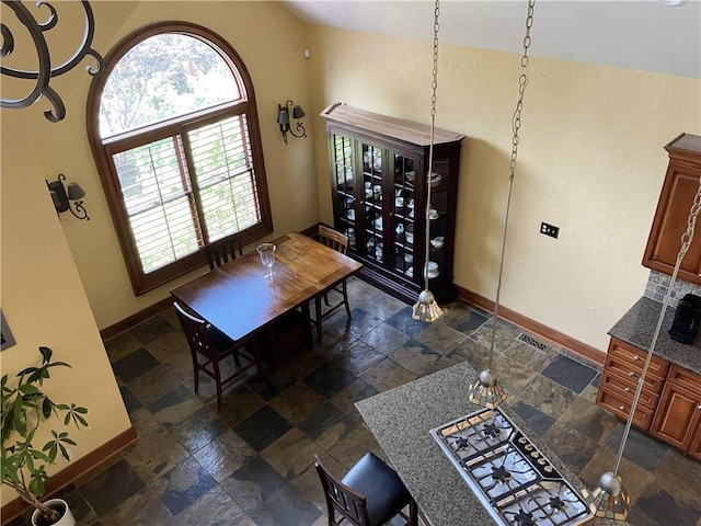 207 W 66th St, Kansas City, MO 64113 - dining room with stone tile flooring and vaulted ceiling