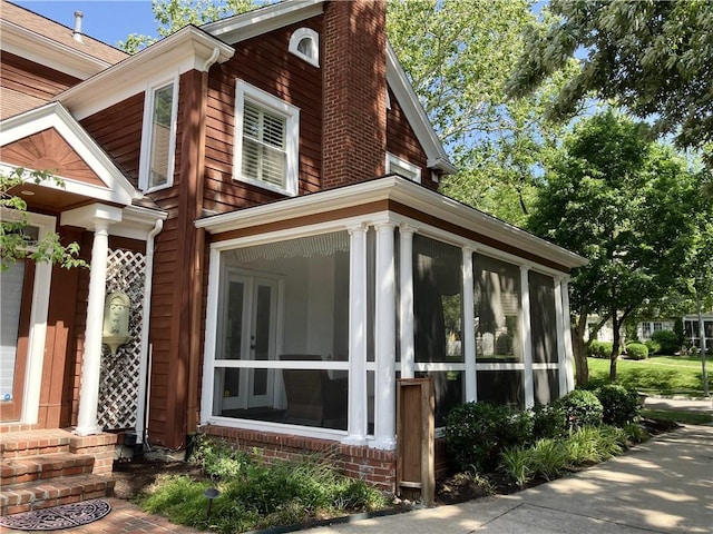 207 W 66th St, Kansas City, MO 64113 - view of property exterior featuring a sunroom and a chimney