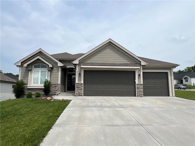 2321 Dovecott Dr, Kearney, MO 64060 - view of front facade featuring a garage, concrete driveway, a front lawn, and stone siding