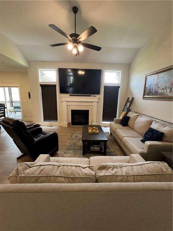 2321 Dovecott Dr, Kearney, MO 64060 - living room with wood finished floors, lofted ceiling, ceiling fan, and a tile fireplace