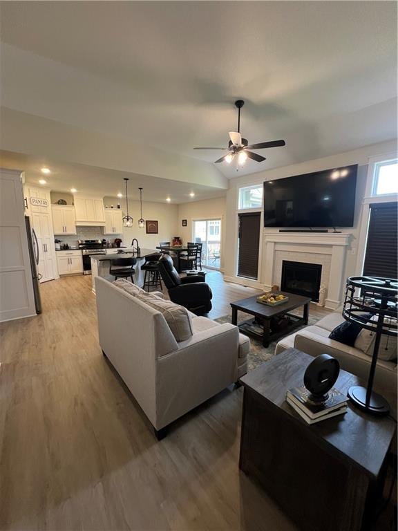 2321 Dovecott Dr, Kearney, MO 64060 - living area with plenty of natural light, light wood-type flooring, a ceiling fan, a fireplace, and recessed lighting