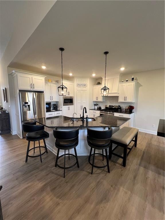 2321 Dovecott Dr, Kearney, MO 64060 - kitchen with appliances with stainless steel finishes, dark countertops, white cabinets, dark wood finished floors, and recessed lighting