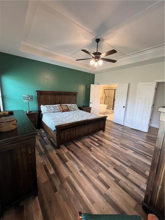 2321 Dovecott Dr, Kearney, MO 64060 - bedroom with wood finished floors, ceiling fan, connected bathroom, and a tray ceiling