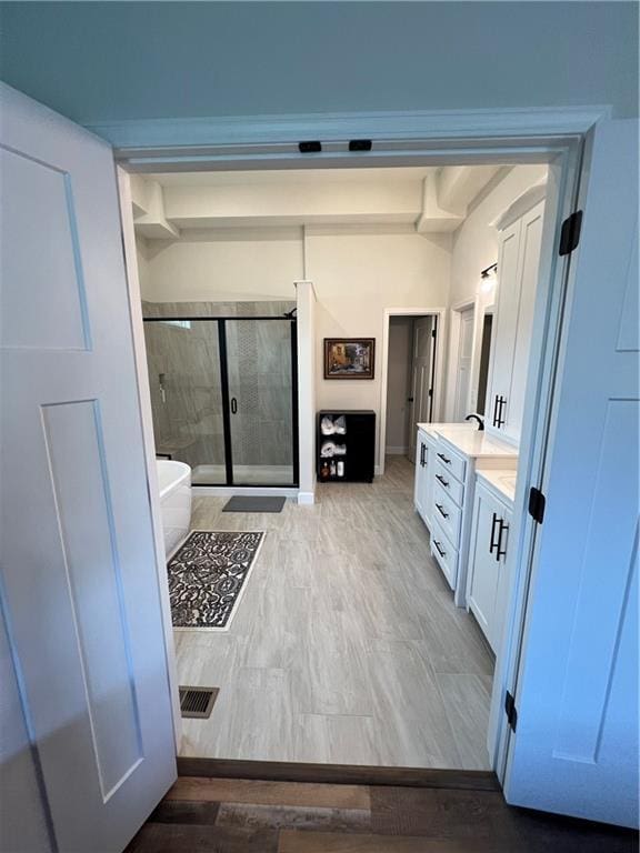 2321 Dovecott Dr, Kearney, MO 64060 - full bath with vanity, a shower stall, a freestanding bath, and wood finished floors