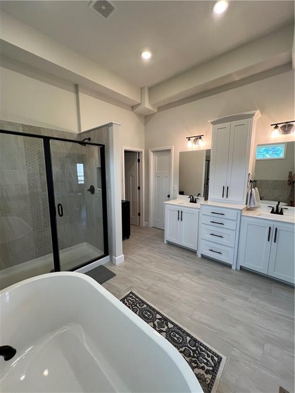 2321 Dovecott Dr, Kearney, MO 64060 - full bath featuring a freestanding bath, double vanity, a shower stall, and recessed lighting