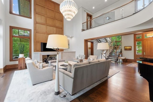 2720 Verona Cir, Mission Hills, KS 66208 - living area featuring a towering ceiling, stairs, wood finished floors, and a chandelier