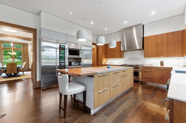 2720 Verona Cir, Mission Hills, KS 66208 - kitchen with built in appliances, wall chimney exhaust hood, modern cabinets, dark wood-style flooring, and a spacious island