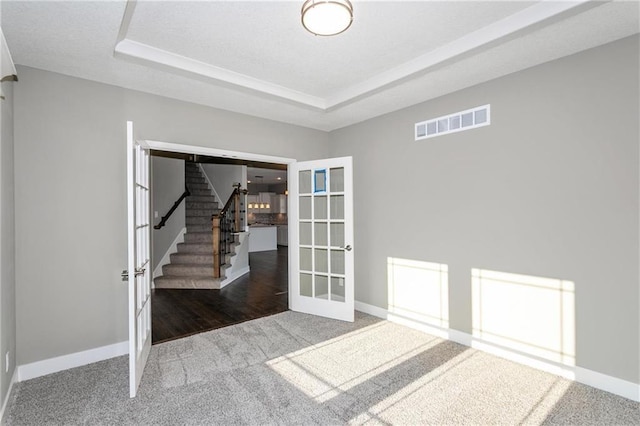 3726 NE 90th Ter, Kansas City, MO 64156 - empty room featuring carpet flooring, french doors, stairs, and a tray ceiling