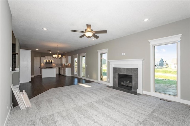 3726 NE 90th Ter, Kansas City, MO 64156 - unfurnished living room featuring dark carpet, a chandelier, a fireplace, recessed lighting, and a ceiling fan