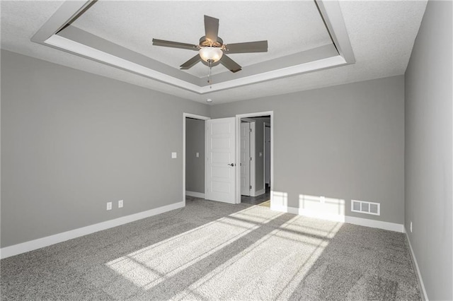 3726 NE 90th Ter, Kansas City, MO 64156 - unfurnished bedroom featuring a tray ceiling, carpet, a textured ceiling, and ceiling fan