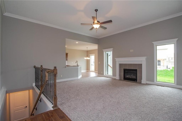 8911 N Monroe Ave, Kansas City, MO 64156 - unfurnished living room featuring crown molding, a tiled fireplace, a ceiling fan, a chandelier, and wood finished floors