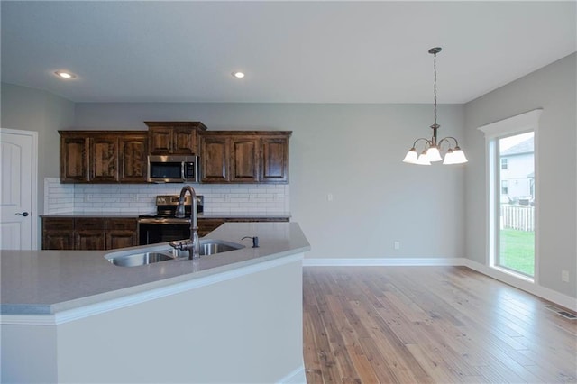 8911 N Monroe Ave, Kansas City, MO 64156 - kitchen featuring stainless steel microwave, plenty of natural light, electric range oven, backsplash, and recessed lighting