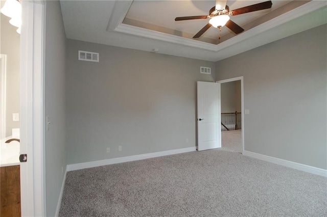 8911 N Monroe Ave, Kansas City, MO 64156 - carpeted empty room featuring a tray ceiling and a ceiling fan