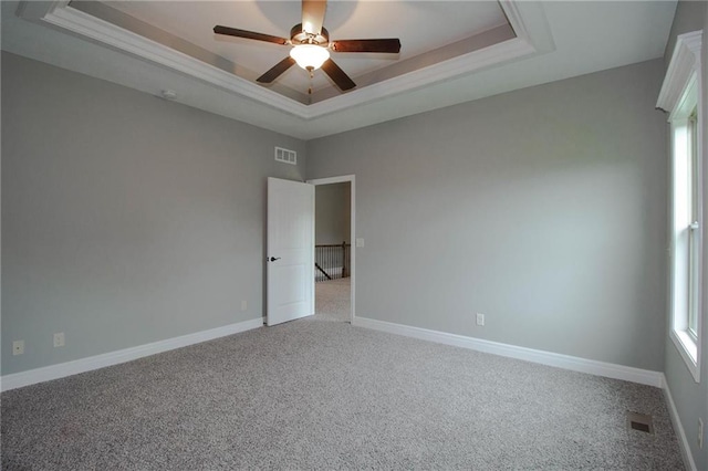 8911 N Monroe Ave, Kansas City, MO 64156 - spare room with a tray ceiling, carpet, and a ceiling fan