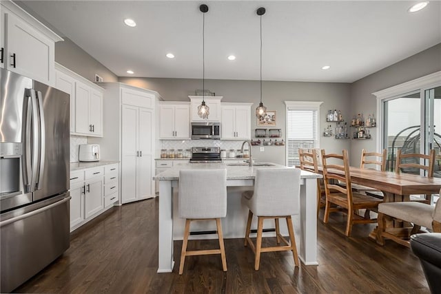 14168 Nicollete Ct, Basehor, KS 66007 - kitchen with stainless steel appliances, backsplash, white cabinetry, dark wood-style flooring, and recessed lighting
