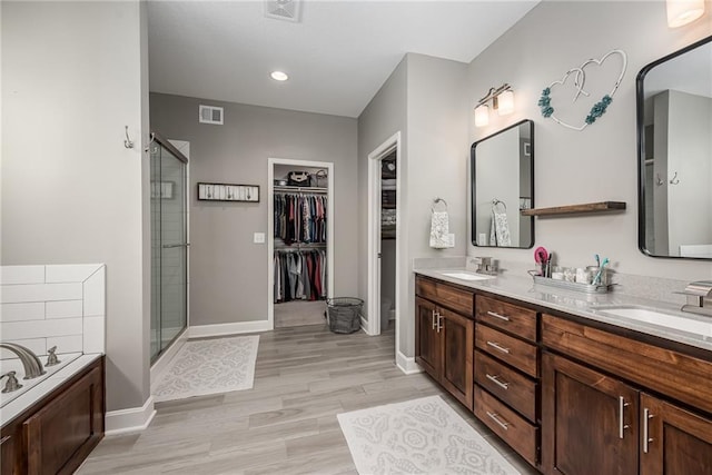 14168 Nicollete Ct, Basehor, KS 66007 - full bath featuring a shower stall, double vanity, a walk in closet, wood finished floors, and a garden tub