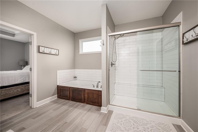 14168 Nicollete Ct, Basehor, KS 66007 - ensuite bathroom with a bath, a stall shower, and wood finished floors