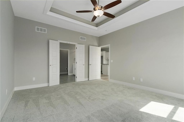 3720 NE 90th St, Kansas City, MO 64156 - unfurnished bedroom featuring carpet, a raised ceiling, connected bathroom, and ceiling fan