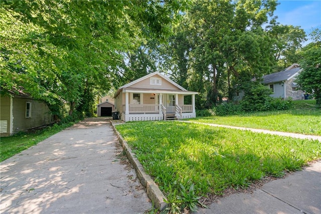 3640 Cleveland Ave, Kansas City, MO 64128 - bungalow-style home with covered porch, concrete driveway, an outdoor structure, a front lawn, and a garage