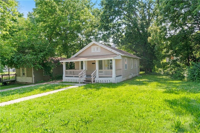 3640 Cleveland Ave, Kansas City, MO 64128 - bungalow-style house featuring covered porch, a front yard, and crawl space