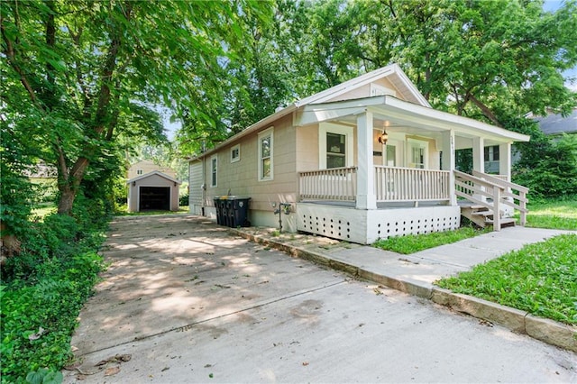 3640 Cleveland Ave, Kansas City, MO 64128 - bungalow-style home with a porch, an outdoor structure, concrete driveway, and a detached garage
