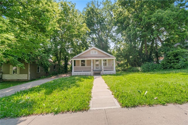3640 Cleveland Ave, Kansas City, MO 64128 - bungalow with a porch and a front lawn