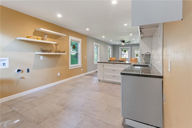 3640 Cleveland Ave, Kansas City, MO 64128 - kitchen with white cabinets, recessed lighting, ceiling fan, a peninsula, and dark countertops
