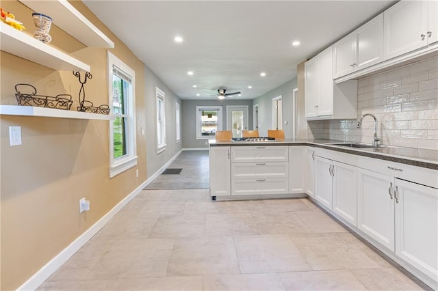 3640 Cleveland Ave, Kansas City, MO 64128 - kitchen featuring recessed lighting, a peninsula, tasteful backsplash, white cabinetry, and ceiling fan