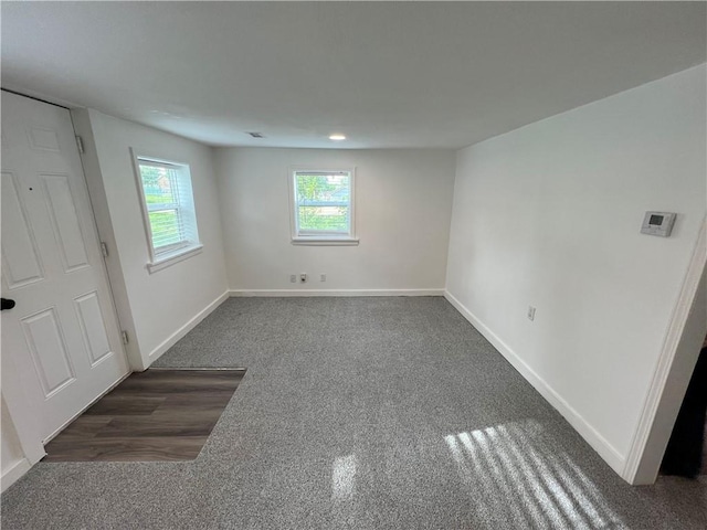 7104 N Cherry St, Gladstone, MO 64118 - empty room with healthy amount of natural light and dark carpet