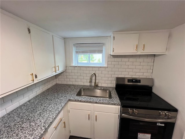 7104 N Cherry St, Gladstone, MO 64118 - kitchen with stainless steel electric range, tasteful backsplash, and white cabinets