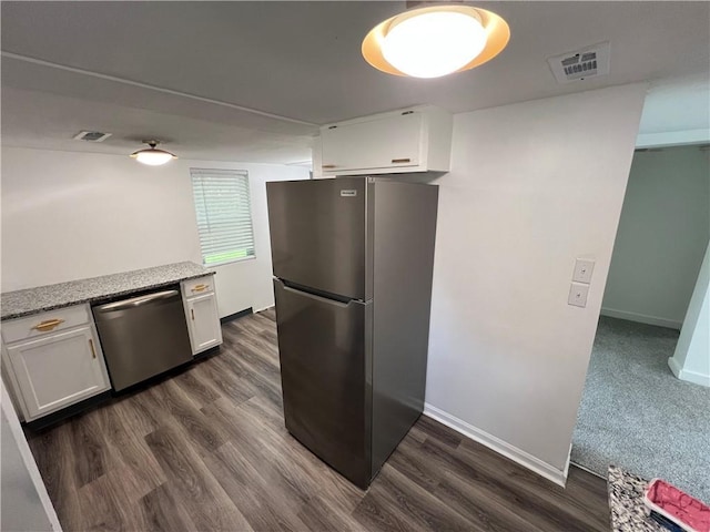 7104 N Cherry St, Gladstone, MO 64118 - kitchen featuring stainless steel appliances, white cabinetry, dark wood-style flooring, and light stone countertops